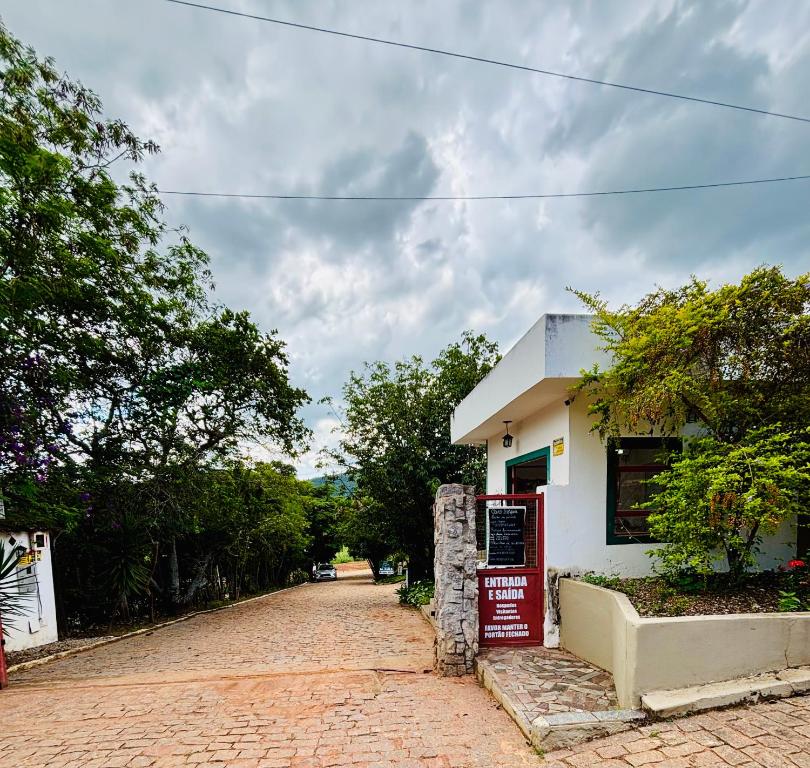 a building with a sign on the side of a road at Pousada Flat Royal - Flat 03 in Itapecerica