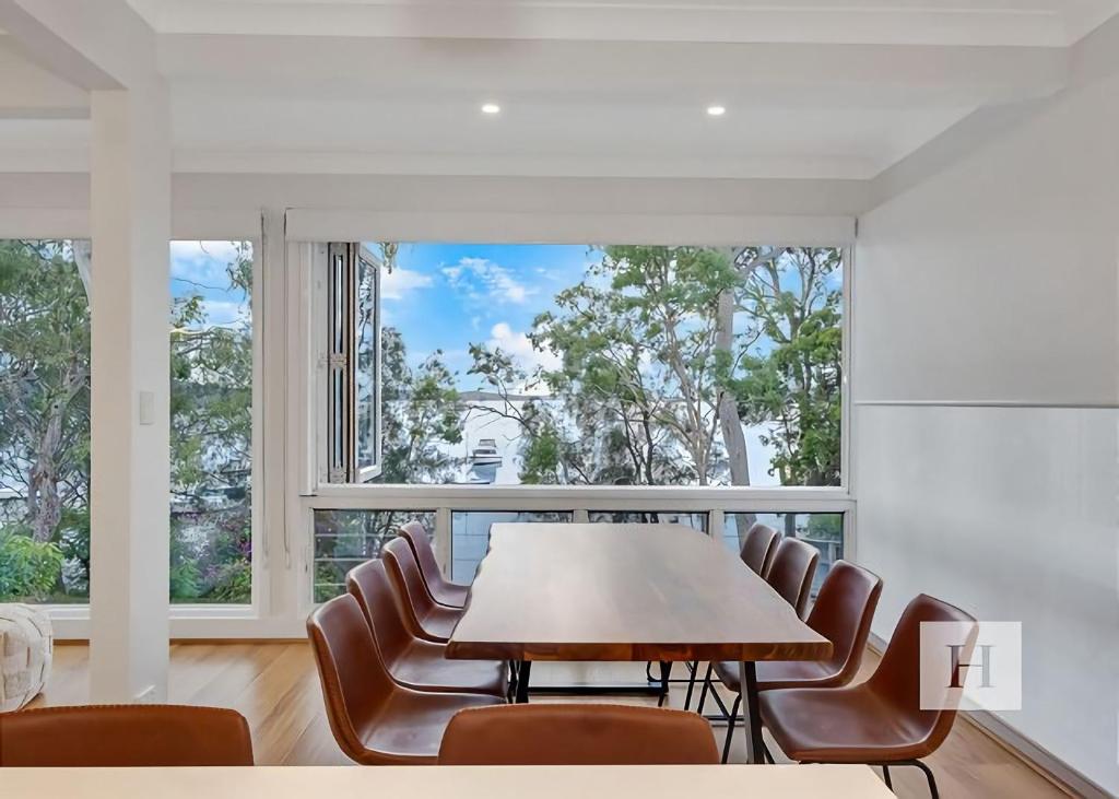 a dining room with a table and chairs and a large window at Angels Little Haven in Cams Wharf