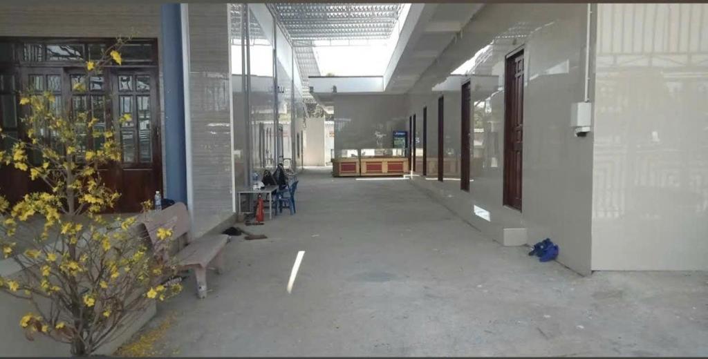 an empty hallway of a building with benches and windows at Nhà Nghỉ La Gi in Lagi