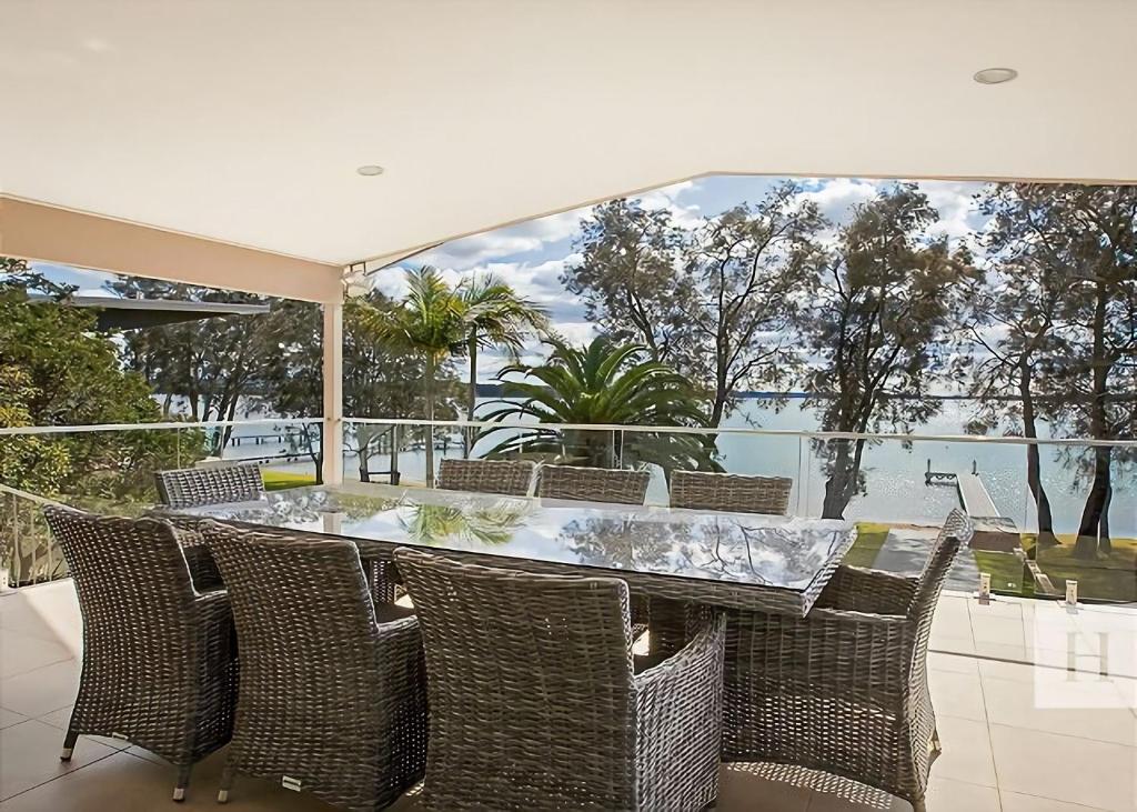 a dining room with a table and chairs on a patio at Enjoy Lazy Daze in Summerland Point