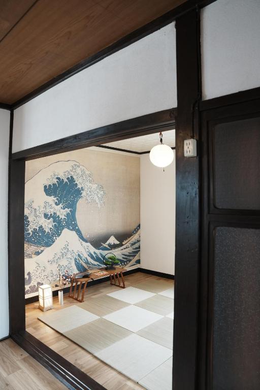 a mural of the great wave on the wall in a room at 8人宿泊可 子供添い寝無料 1日1組限定で開放感のある90平米 吉野山天川村40分 奈良大阪1時間 駅から徒歩5分 家主居住型 大淀桜庵 in Oyodo