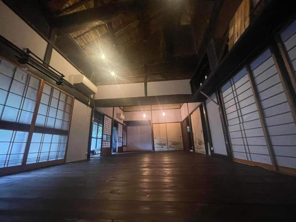 an empty building with a large room with windows at ゲストハウス　竹亭 in Marugame