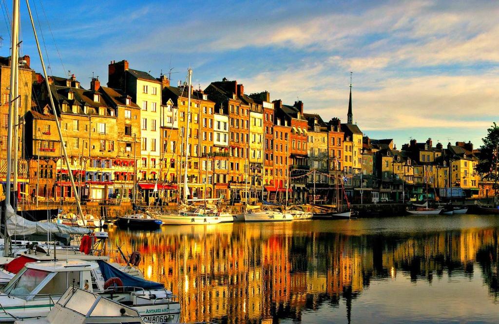 a group of boats docked in a harbor with buildings at Le Bellevue Honfleur in Honfleur