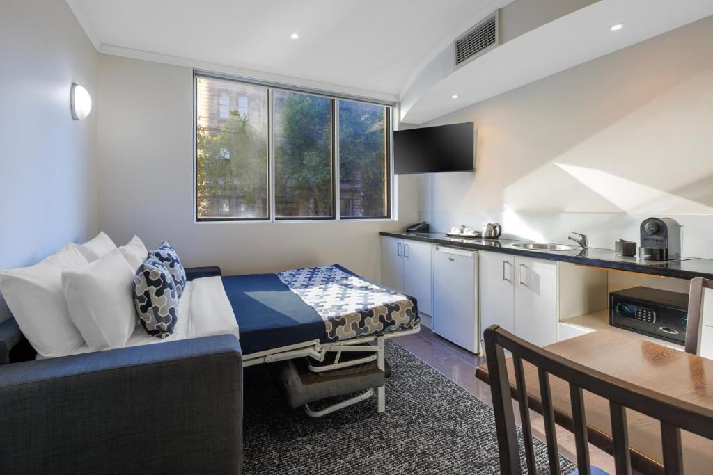 a small room with a bed and a kitchen at Great Southern Hotel Melbourne in Melbourne