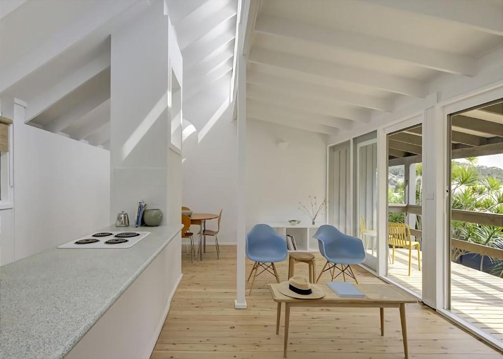 a kitchen with two blue chairs and a table at Norah Beach Shack 2 in Norah