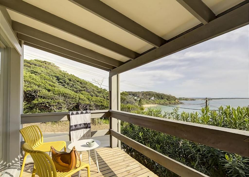 a porch with two chairs and a view of the water at Norah Beach Shack 1 in Norah