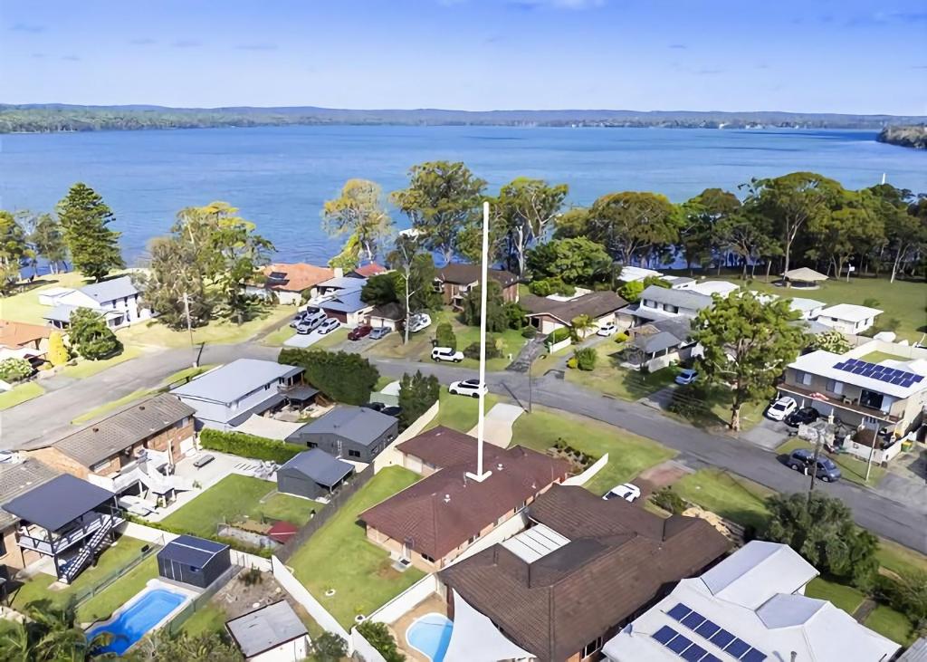 an aerial view of a suburb with a lake at The Sailor s Haven in Mannering Park