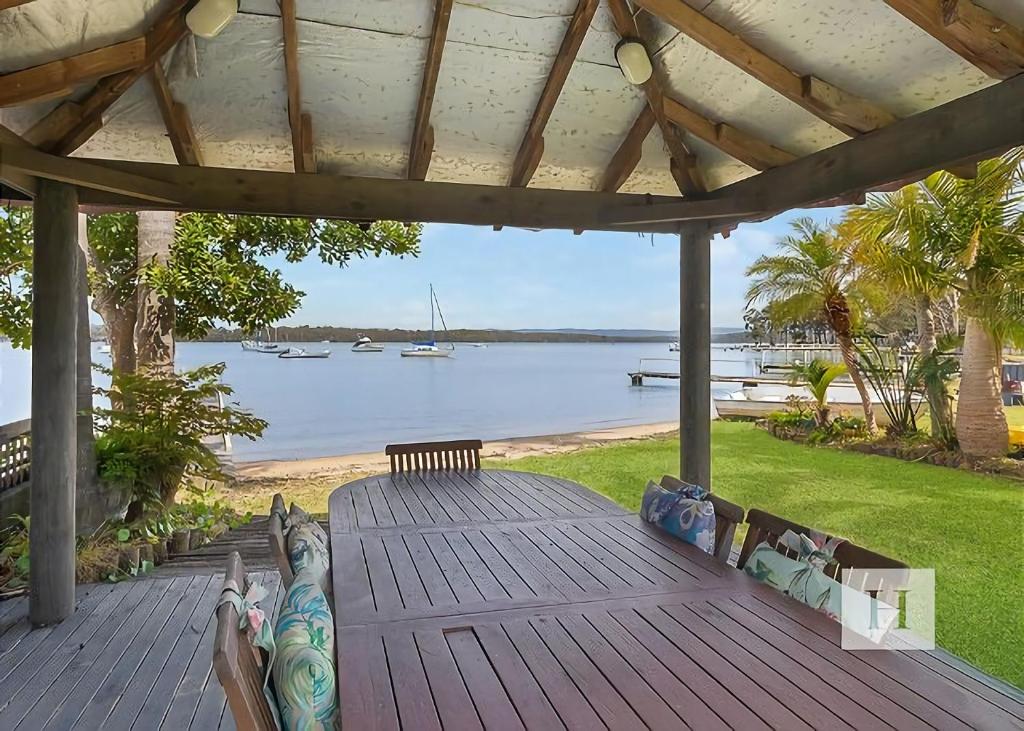a wooden deck with a view of the water at Paradise Palms in Mannering Park