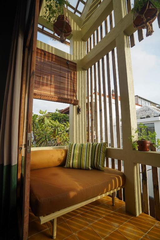 a bench on the porch of a house at Songbird Boutique Inn in Canggu