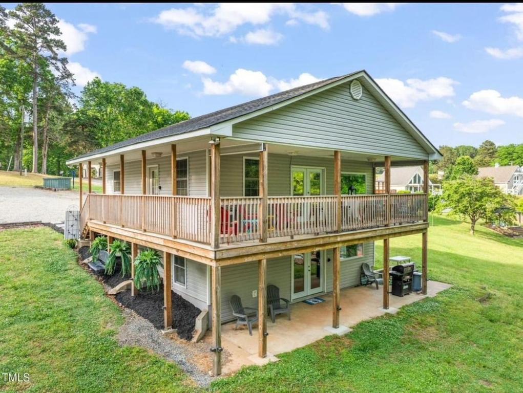 a large green house with a large deck at Dockside Dreamz 2 with beach & dock in Clarksville