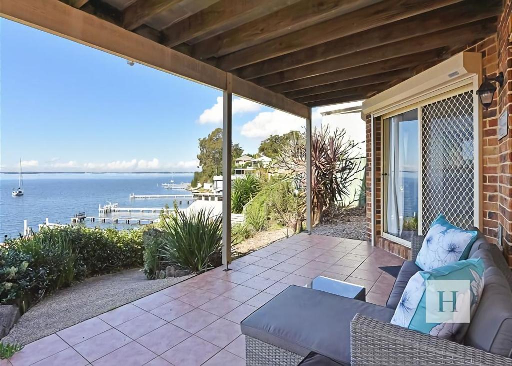a patio with a couch and a view of the water at Sparkling Waters in Rathmines