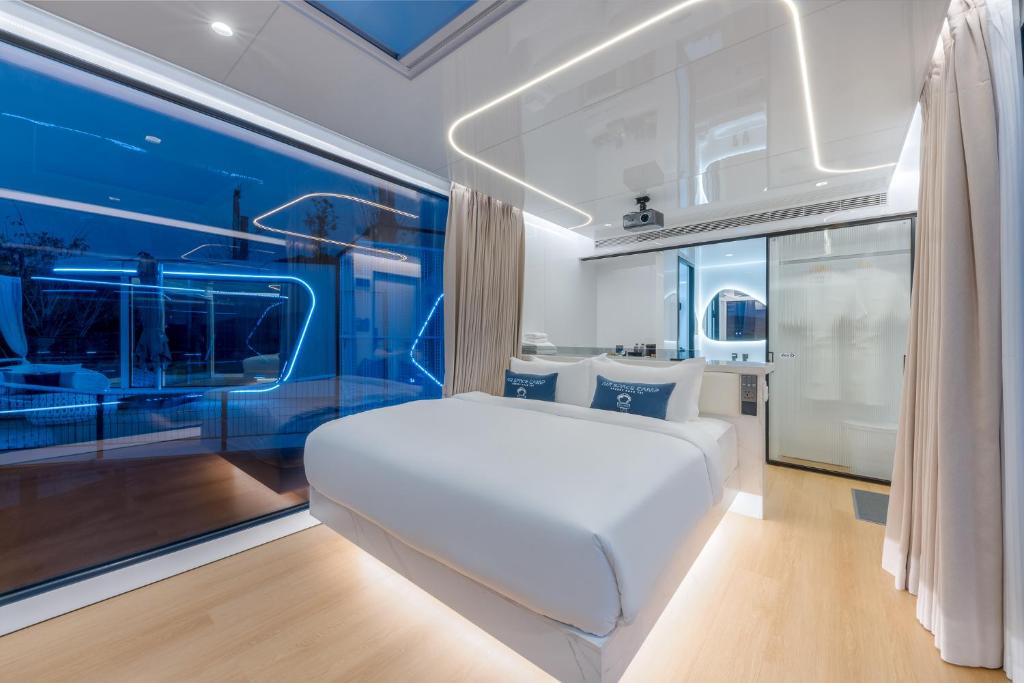 a bedroom with a white bed and blue walls at Air Space Camp Khao Yai in Pak Chong