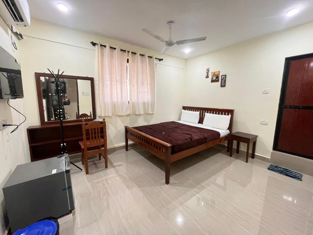 a bedroom with a bed and a mirror and a television at The cozy Inn in Calangute
