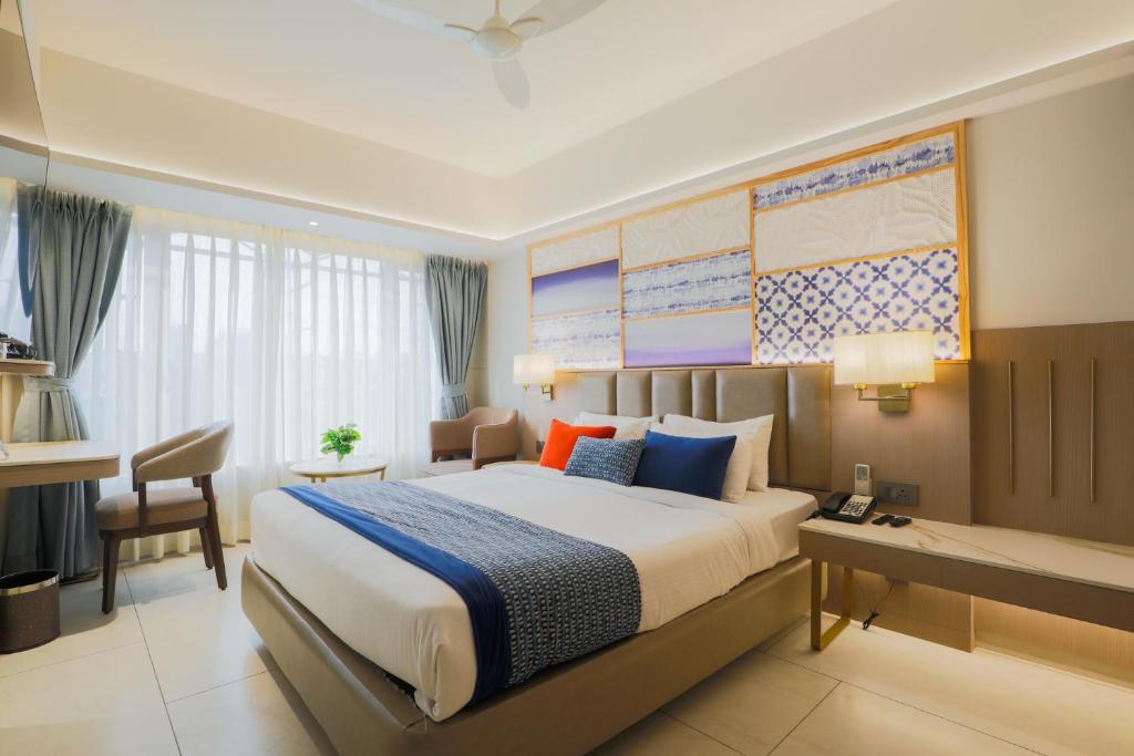 a bedroom with a large bed with a desk and a desk at Hotel Silver Inn Near Mumbai Airport in Mumbai