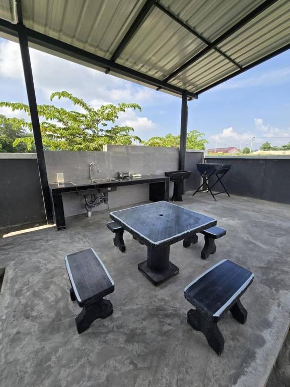 a ping pong table and two benches on a patio at Infra Homestay 1 in Marang