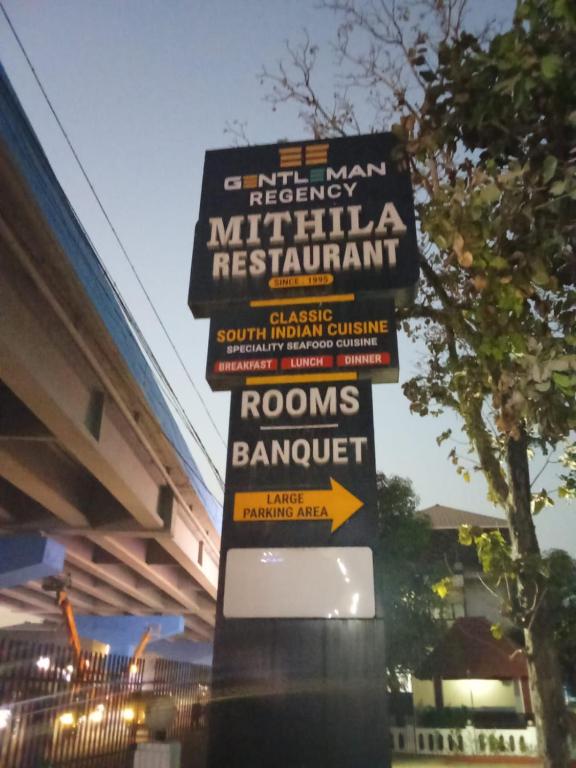 a sign for a restaurant on the side of a building at Hotel Gentleman Mithila in Eramalloor