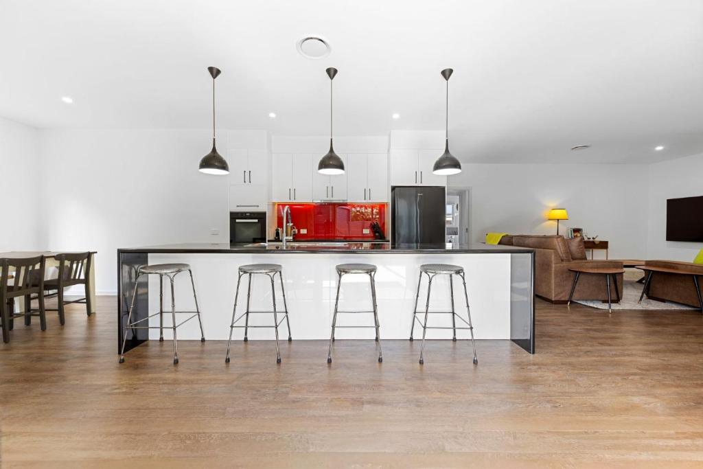 a kitchen with a counter and some bar stools at Spacious 4-Bedroom Retreat in Mansfield