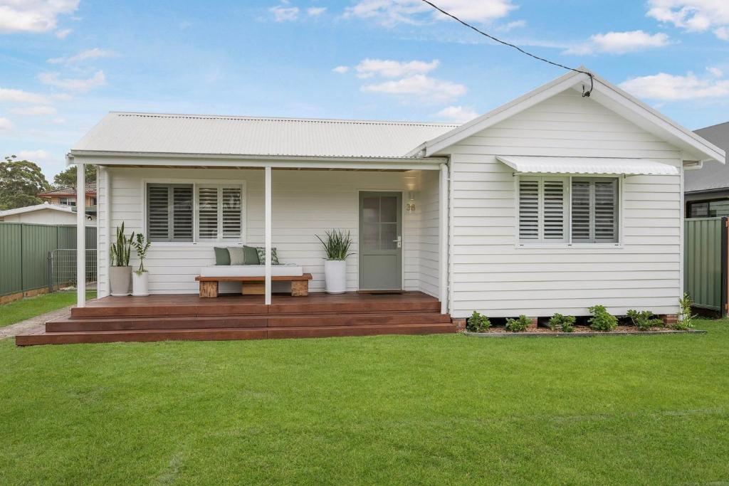 a white house with a wooden deck in a yard at Thirty Eight in North Haven