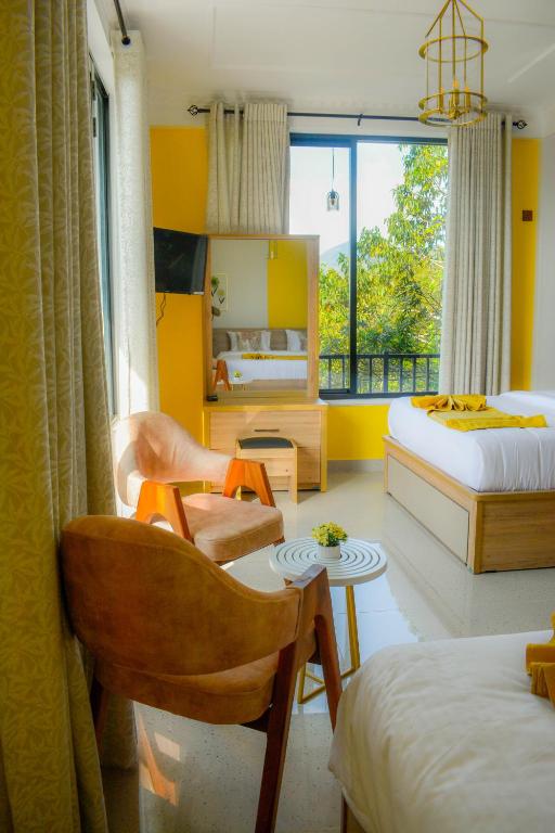 a bedroom with two beds and a chair and a table at 3Arch Eco Cottage Ella in Ella