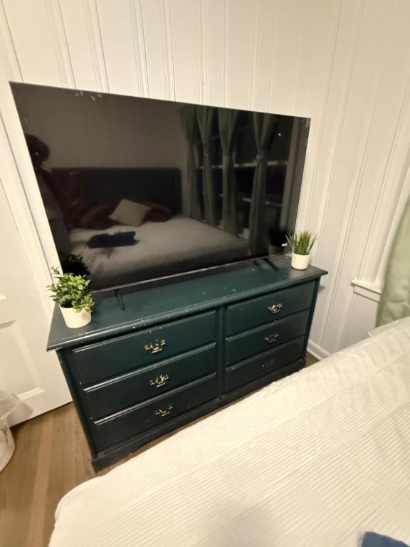 a bedroom with a dresser with a mirror at April Palace green in Decatur