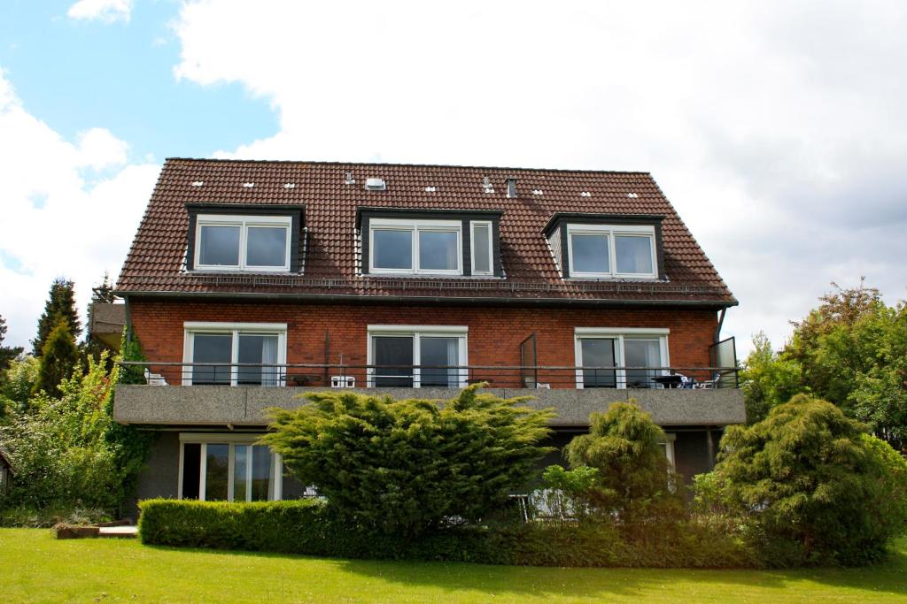 a red brick house with a balcony on top at Ferienwohnung Bockholm Appartement 1 - 8 in Glücksburg