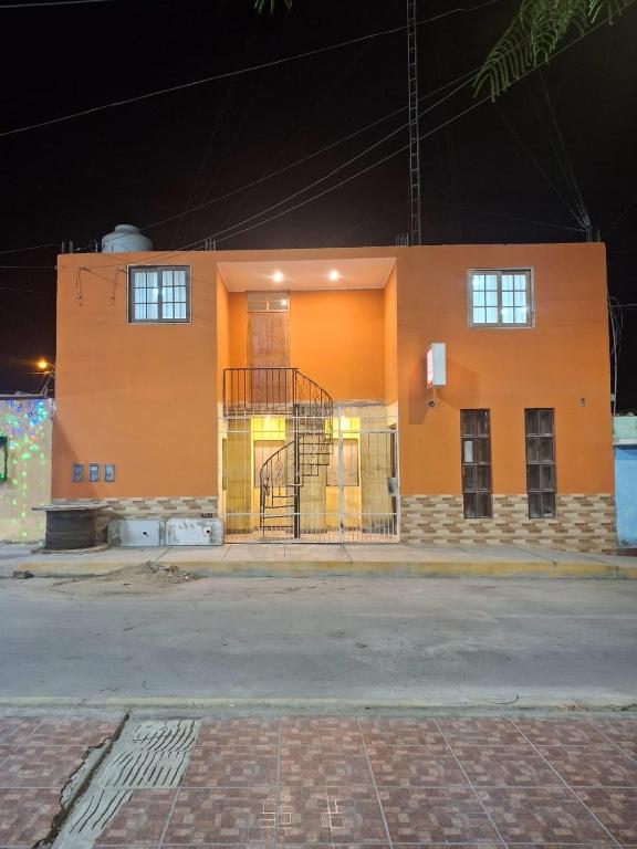 an orange building with windows on the side of it at Hospedaje AMAPI - San José in El Carmen