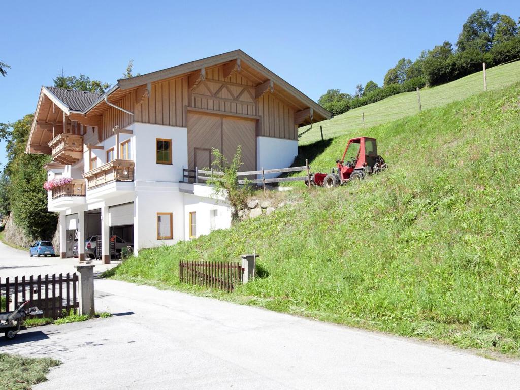 a house on a hill with a tractor in front of it at Chalet in Mittersill near Ski Slopes in Mittersill