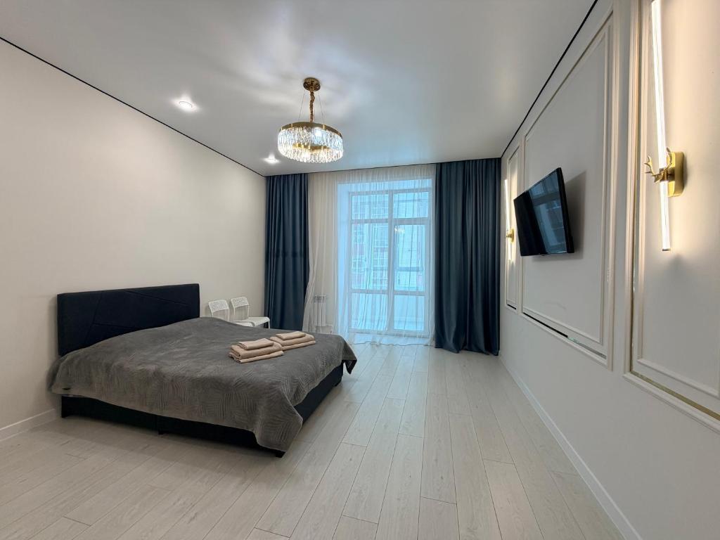 a bedroom with a bed and a large window at Atamura 1 in Karagandy
