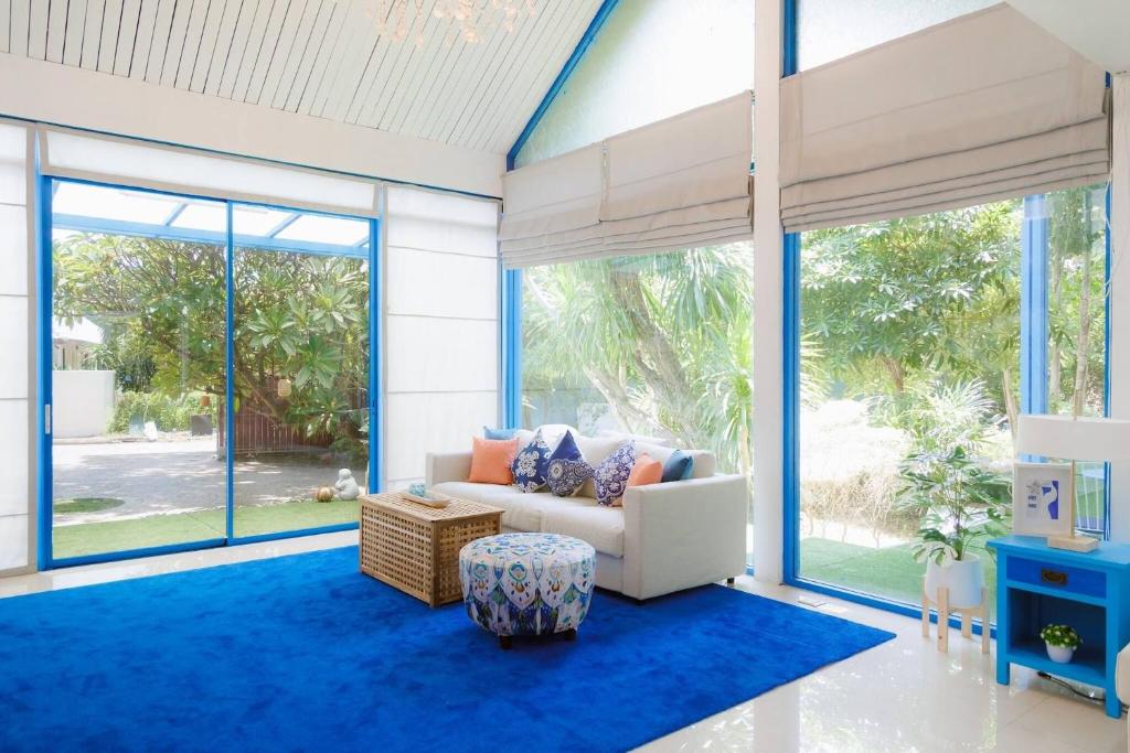 a living room with a couch and large windows at Private Pool Party Villa games Karaoke, in Nonthaburi