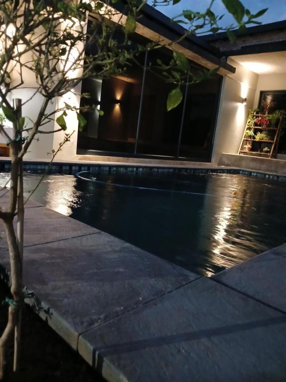 a swimming pool in a house at night at the Host at Bingos House Self Catering in Thohoyandou