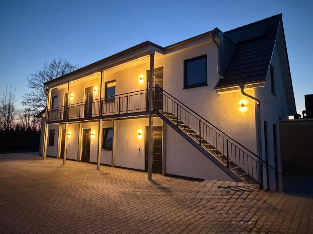 a white building with a staircase on the side of it at Haus Bahnhofsblick in Ottersberg