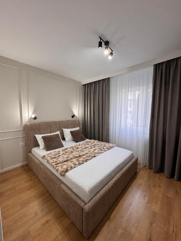 a bedroom with a large bed in front of a window at Olt view apartament in Călimăneşti