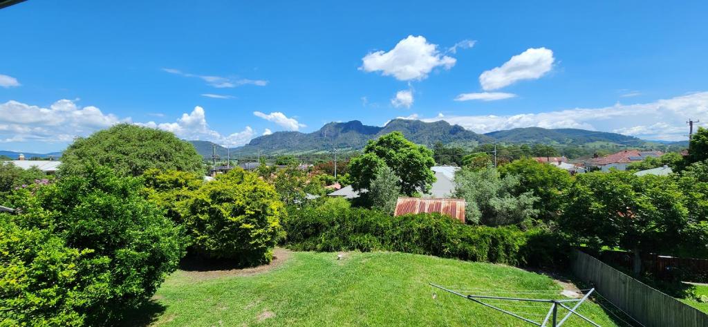 a green yard with trees and mountains in the background at Gloucester View in Gloucester
