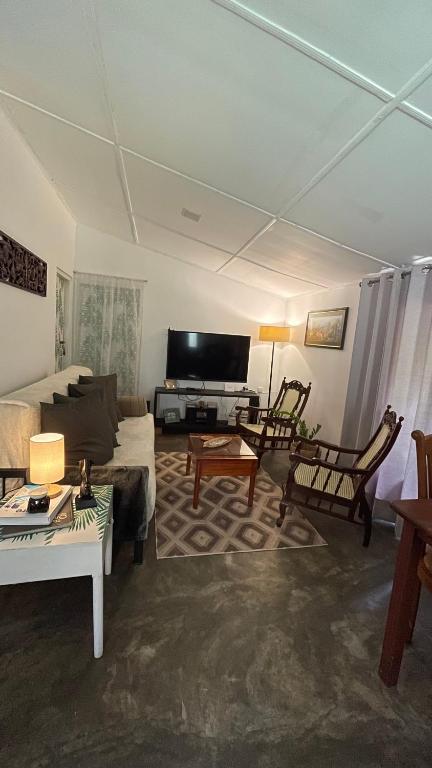 a living room with a couch and a tv at LAZA villa in Nuwara Eliya