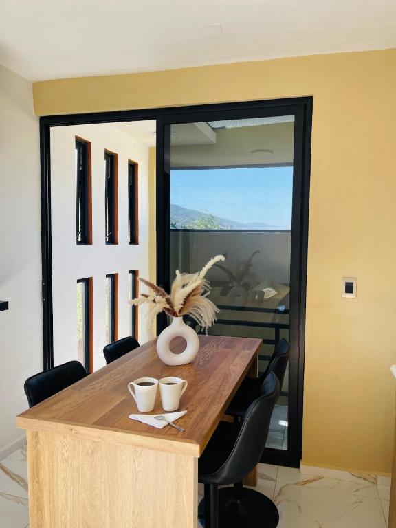 a dining room with a wooden table and chairs at Casa Mancera Oaxaca in Yelateni