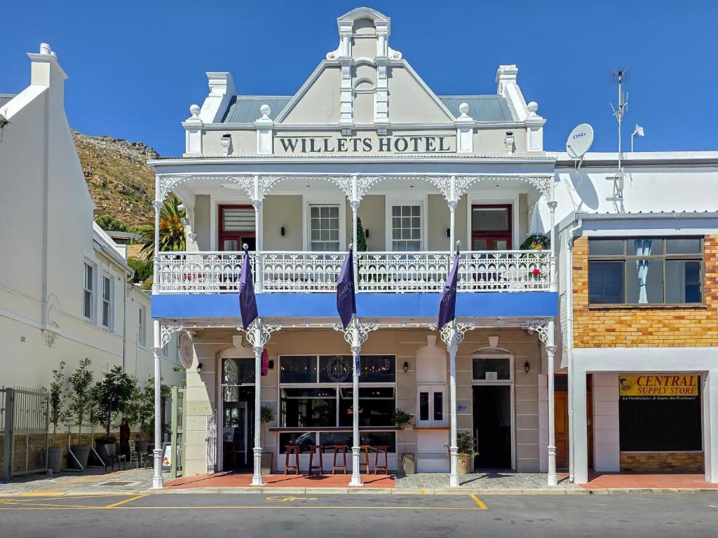 a white building with a balcony on a street at The Willets Boutique Hotel in Simonʼs Town