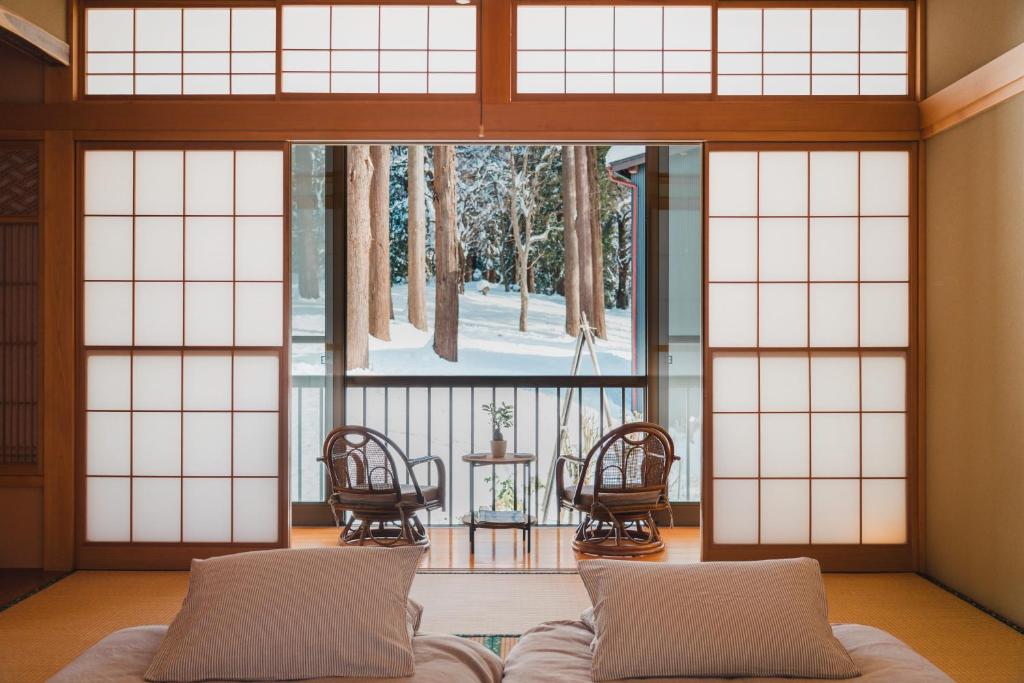 a living room with a couch and a large window at Ao No Mori in Myoko
