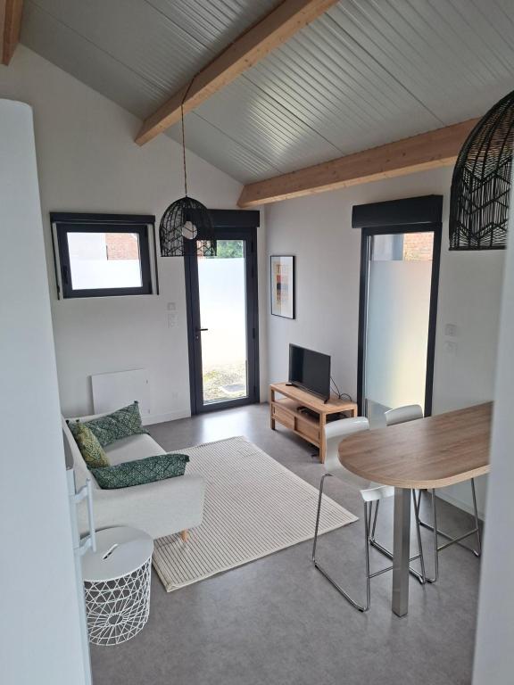 a living room with a table and a couch at Le cottage , logement individuel de plain pied in Villeneuve d'Ascq