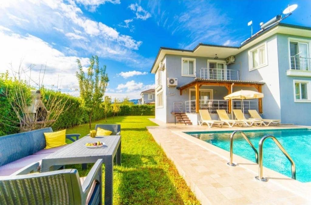 a villa with a swimming pool and a house at Villas Dogakent in Ortaca