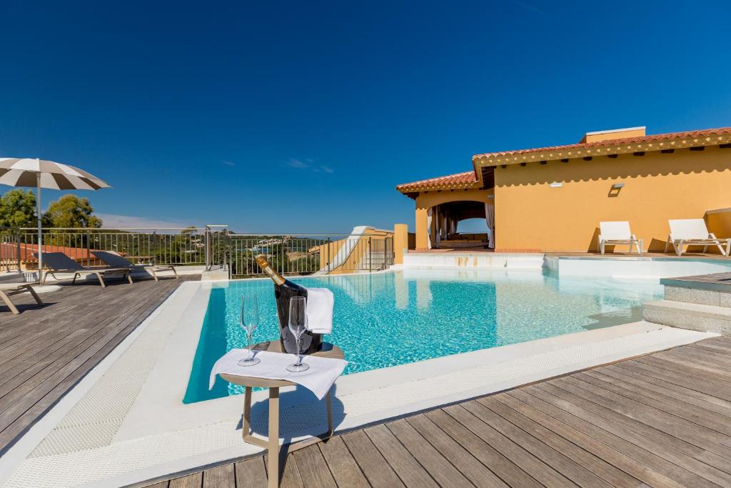 a villa with a swimming pool and a house at Hotel Marana in Golfo Aranci