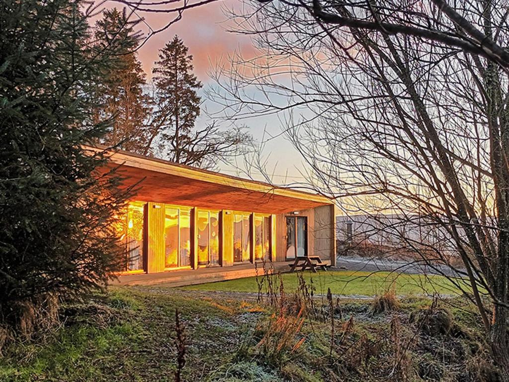 a house with large windows in a field at The Bunkhouse - Uk50470 in Greenhaugh