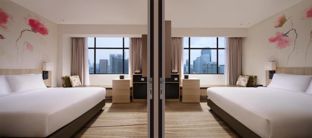 A twin room with two beds, matching desks and skyline-facing windows.