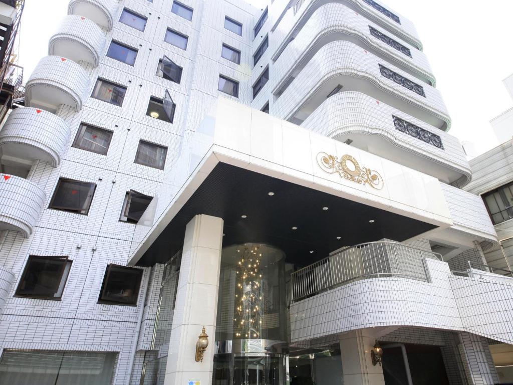 a large white building with a christmas tree in front of it at Hotel Green Pacific in Sendai