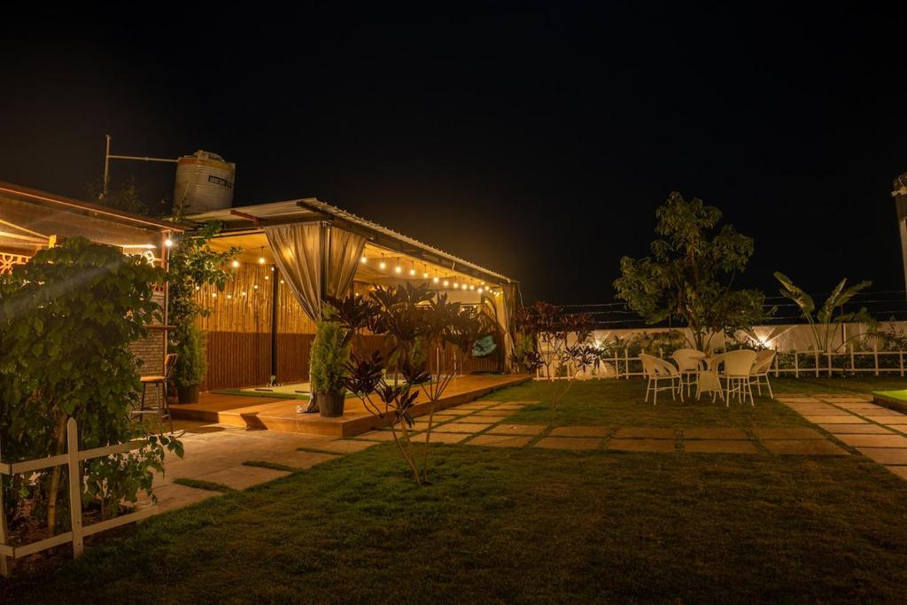 a backyard with a tent and tables and chairs at night at The Leafyard Container Home in Venkatāpur