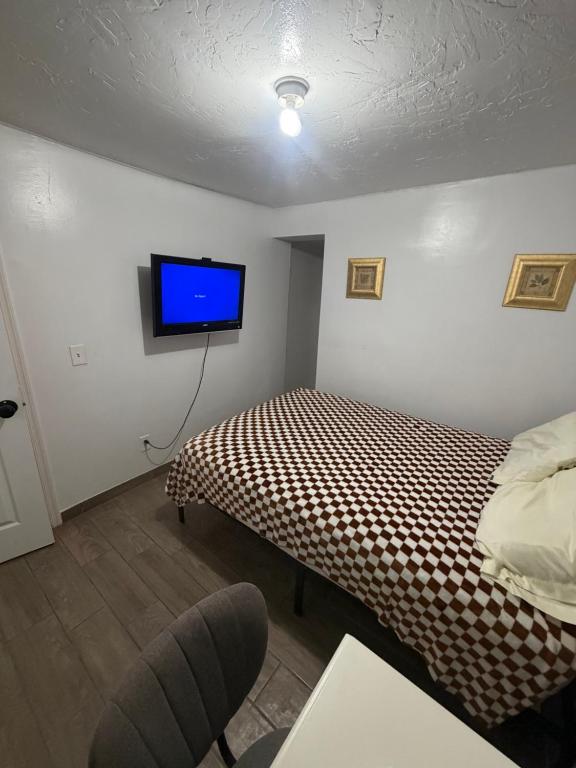 a bedroom with a bed and a tv on the wall at Downtown Taylor Room 5 in Phoenix