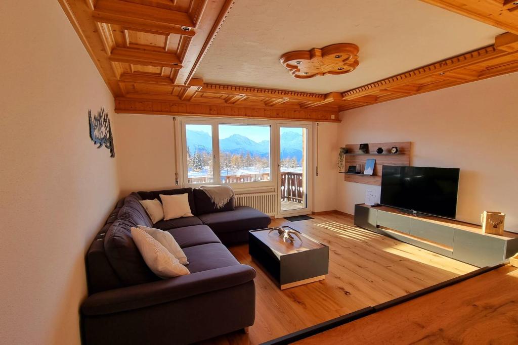 a living room with a couch and a flat screen tv at Hollandia 26 in Riederalp