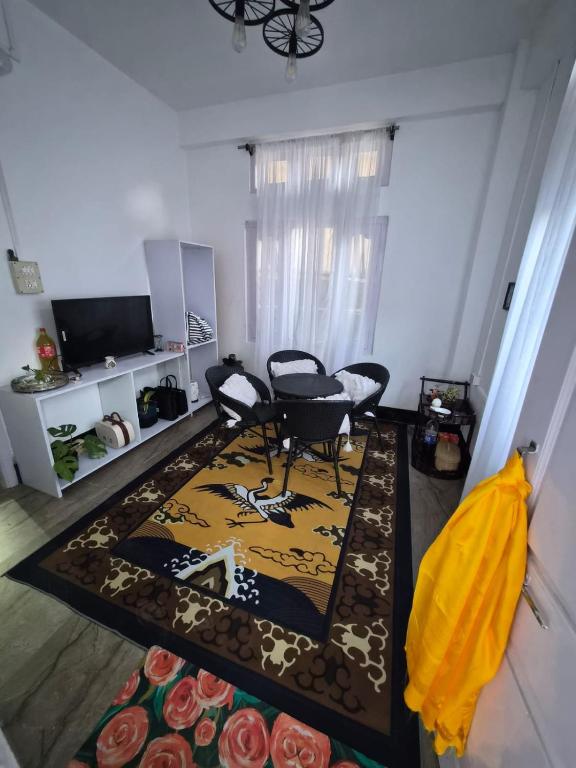 ein Wohnzimmer mit Tisch, Stühlen und einem Teppich in der Unterkunft Shring's Abode in Dirang Dzong