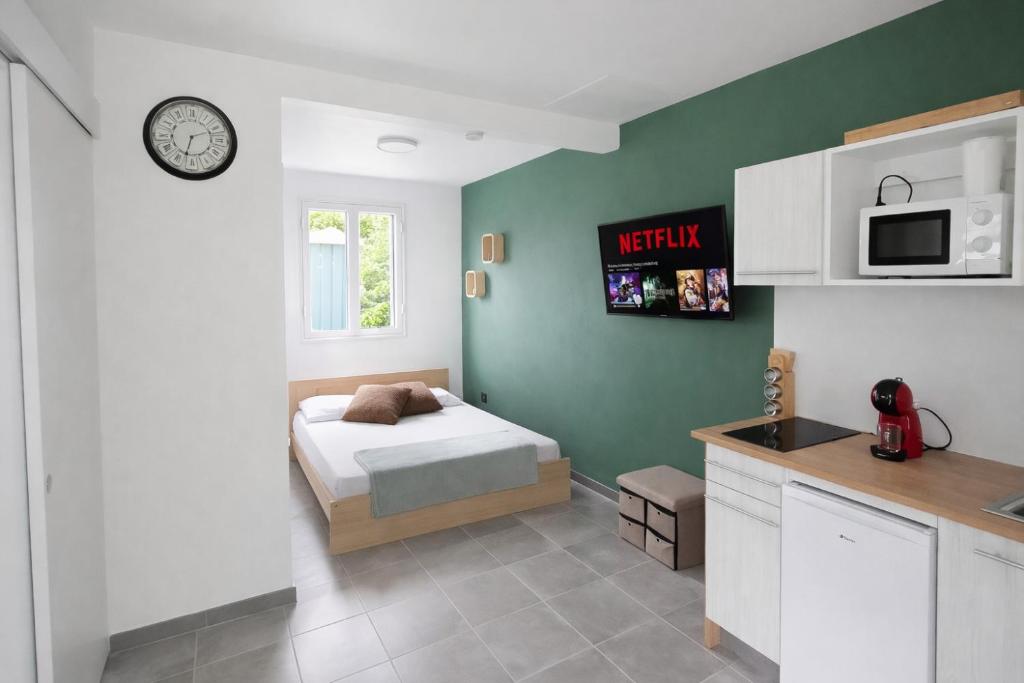 a small bedroom with a bed and a kitchen at Kaza Domi studio in Le Lamentin