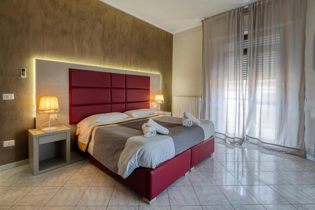 a bedroom with a large bed with a red headboard at Sant'Oronzo House in Lecce