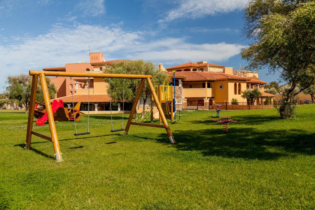 a park with a swing set in the grass at Hotel Marana in Golfo Aranci